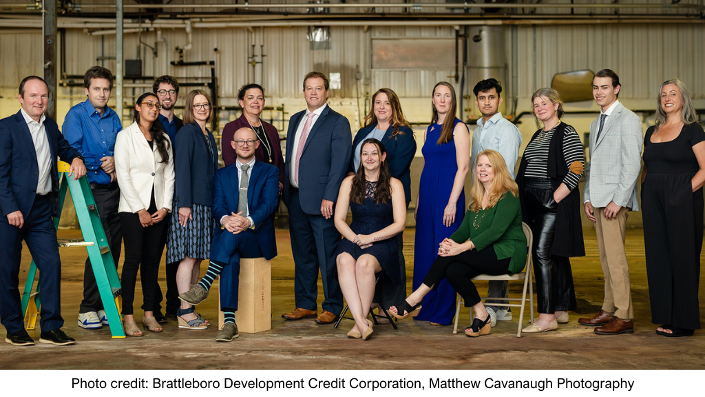 a group of employees from BDCC pose for a photo with an industrial building background